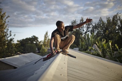 An M-POWER agent installs a solar panel in Tanzania. (Image credit: Mathieu Young / Off Grid Electric).