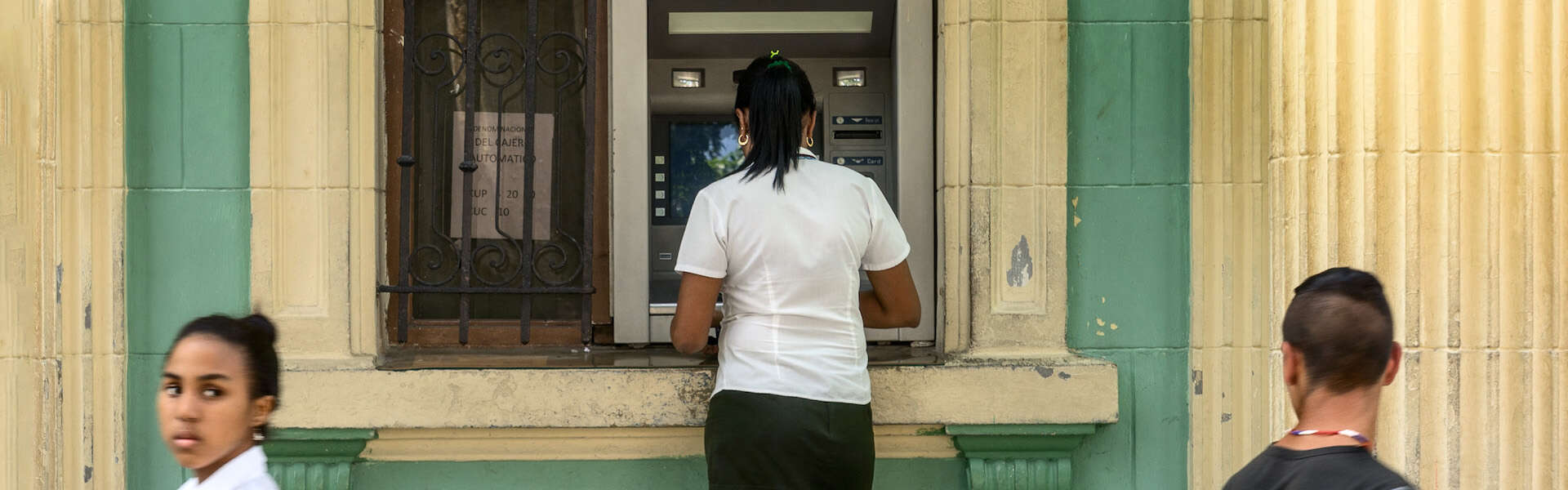 Woman using ATM in Cuba