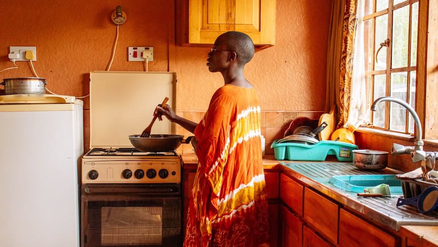 African woman cooking with gas stove