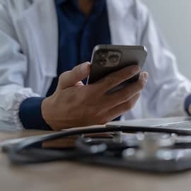 Photo purchased on iStock / no attribution necessary / https://www.istockphoto.com/photo/doctor-using-mobile-smartphone-working-on-laptop-computer-in-medical-office-close-gm2155793304-576587644