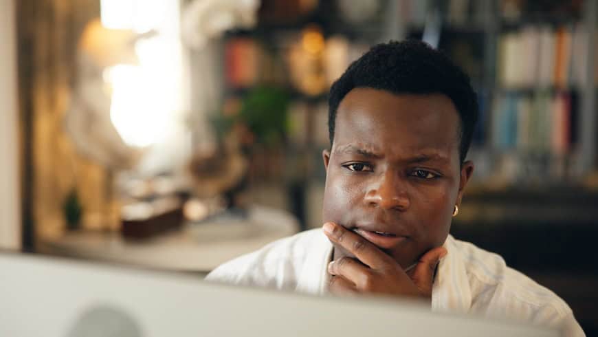 Student, man and thinking by computer at night for research solution, university thesis or problem solving. Studying, black person and online course with proposal planning, elearning or ideas in home