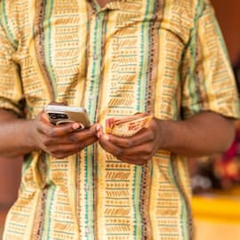 https://www.istockphoto.com/photo/mobile-money-customer-counts-cash-after-withdrawal-transaction-at-an-outdoor-stand-gm2238020828-653081555